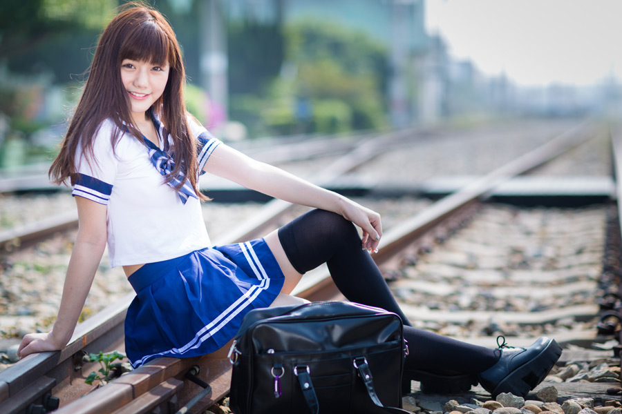 フリー 写真セーラー服姿で線路の上に腰掛ける女子高生