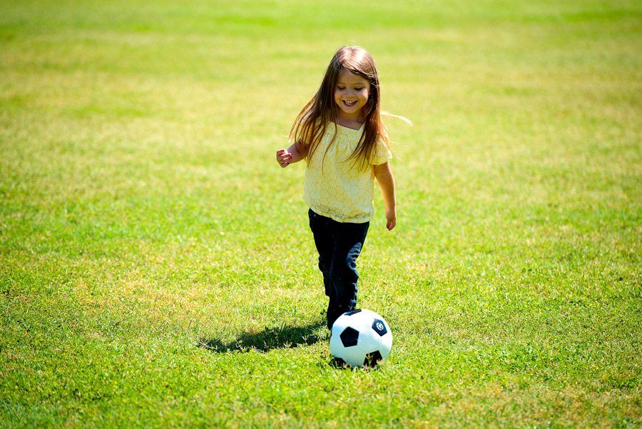 フリー写真 笑顔でサッカーをする外国の女の子