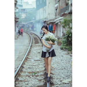 フリー写真, 人物, 少女, アジアの少女, 少女（00118), ベトナム人, 三つ編み, 人と花, 花束, 白色の花, 学生服, 学生（生徒）, 人と風景, 線路（鉄道）, 俯く（下を向く）