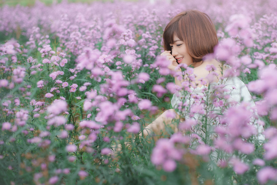 フリー写真 花畑の中で微笑んでいる女性