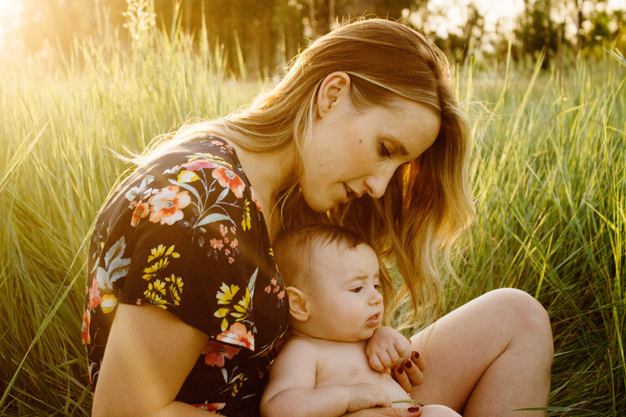 フリー写真 草むらに座っている母親と赤ちゃん