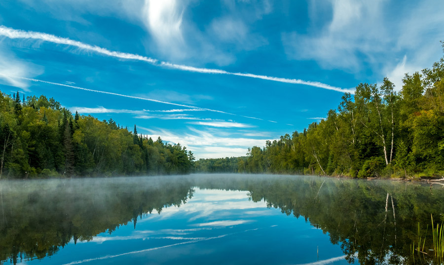 フリー写真 飛行機雲と青空が映る湖の風景